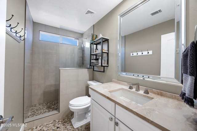 bathroom with toilet, a walk in shower, vanity, and visible vents