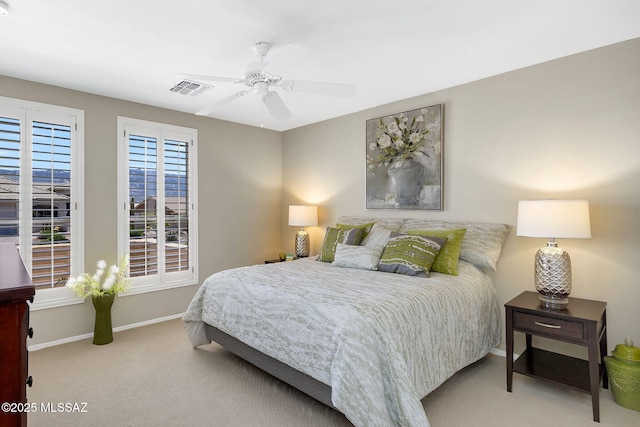 carpeted bedroom with baseboards, a ceiling fan, and visible vents