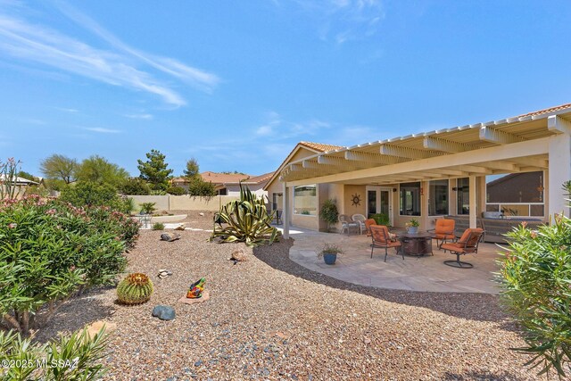 rear view of house featuring a patio, a tiled roof, stucco siding, and fence