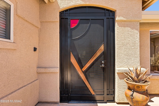 view of exterior entry featuring stucco siding