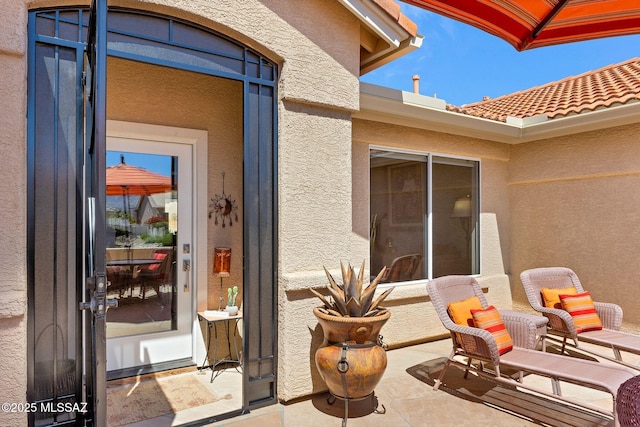 doorway to property featuring stucco siding and a tile roof