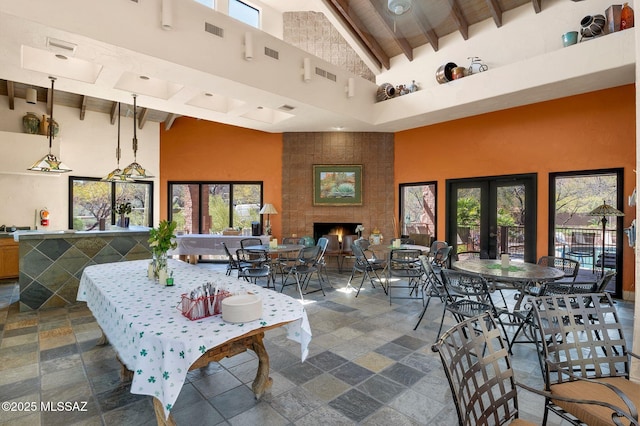 6655 N Canyon Crest Dr Unit 23102, Tucson, AZ 85750 - dining room featuring high vaulted ceiling, wooden ceiling with exposed beams, stone tile floors, plenty of natural light, and a large fireplace