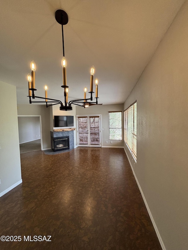 6655 N Canyon Crest Dr Unit 23102, Tucson, AZ 85750 - unfurnished living room with a chandelier, baseboards, and a glass covered fireplace