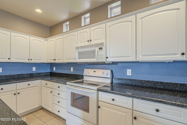 kitchen featuring light tile patterned flooring, white cabinetry, dark stone countertops, white appliances, and recessed lighting