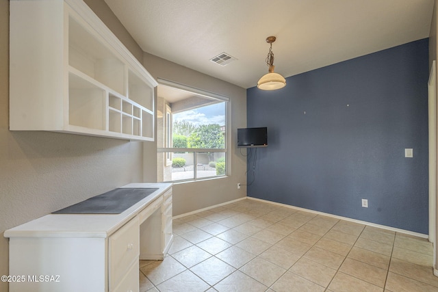 interior space with light tile patterned floors, baseboards, and visible vents