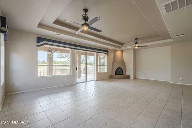 unfurnished living room featuring visible vents, a ceiling fan, and a raised ceiling