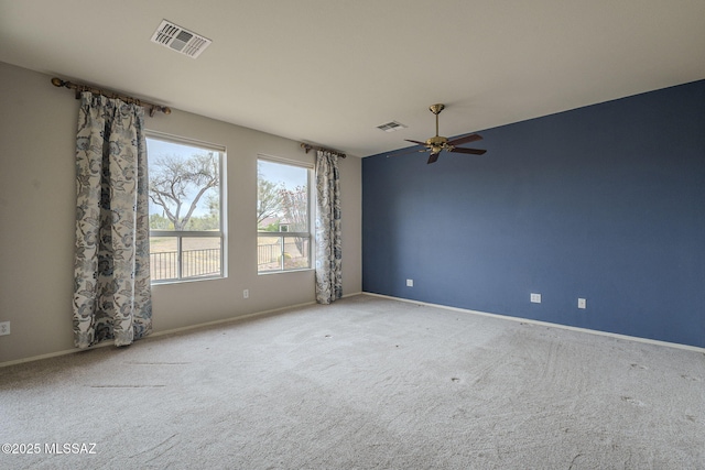 spare room with baseboards, visible vents, carpet, and a ceiling fan