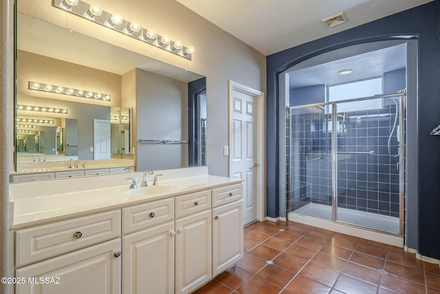 bathroom with visible vents, tile patterned floors, vanity, and a stall shower
