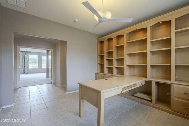 unfurnished office with baseboards, visible vents, light tile patterned floors, and a ceiling fan