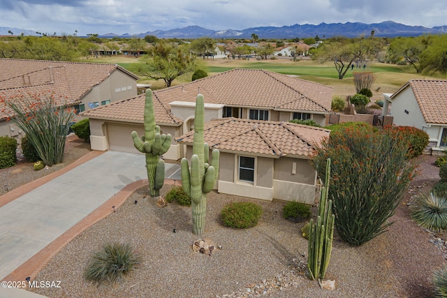 view of front of property with a tile roof, concrete driveway, stucco siding, and a garage