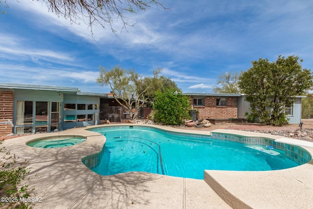 outdoor pool featuring an in ground hot tub and a patio area
