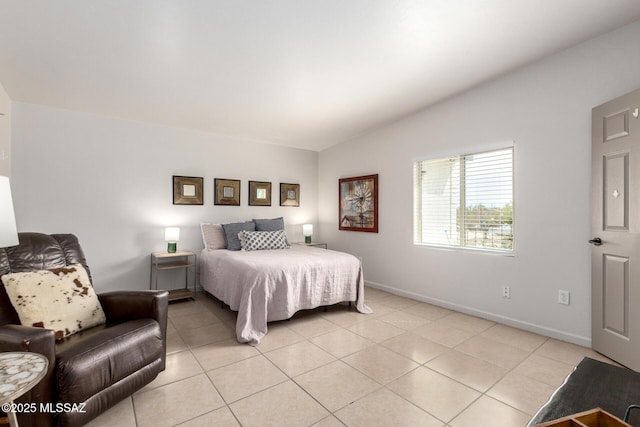 bedroom with light tile patterned floors, baseboards, and vaulted ceiling