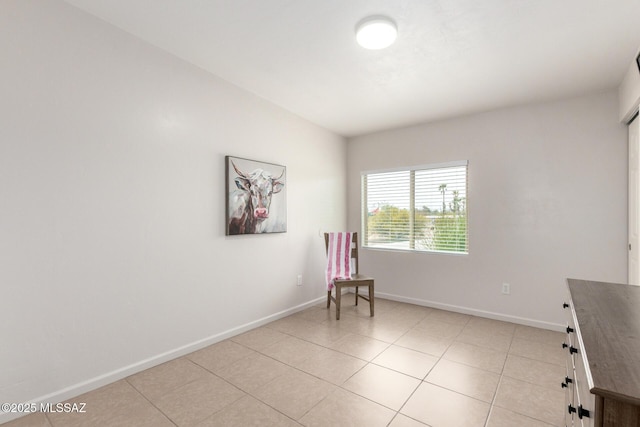 unfurnished room with light tile patterned floors and baseboards