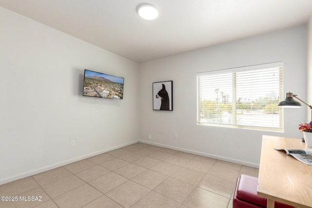 unfurnished office featuring baseboards and light tile patterned floors