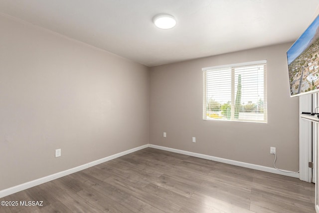 unfurnished room featuring baseboards and wood finished floors