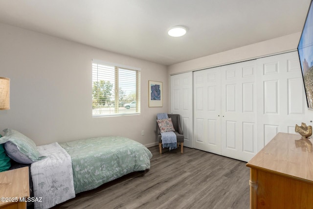bedroom with baseboards, a closet, and wood finished floors