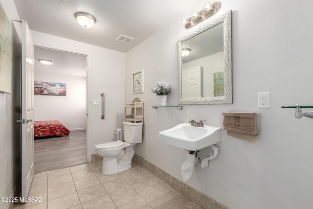 ensuite bathroom with toilet, tile patterned flooring, ensuite bathroom, baseboards, and visible vents