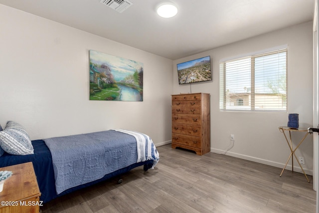 bedroom with baseboards, visible vents, and light wood-style floors