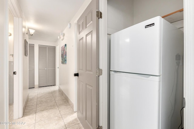 hall with light tile patterned floors and baseboards