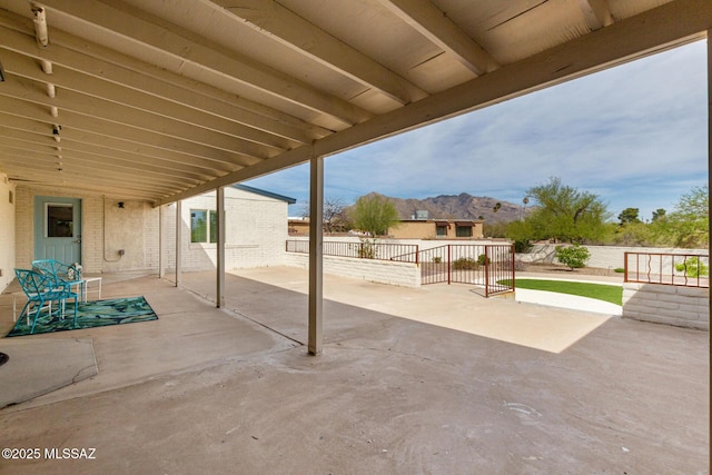 view of patio with a mountain view and fence