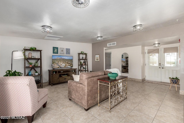 living room with light tile patterned flooring, baseboards, visible vents, and french doors
