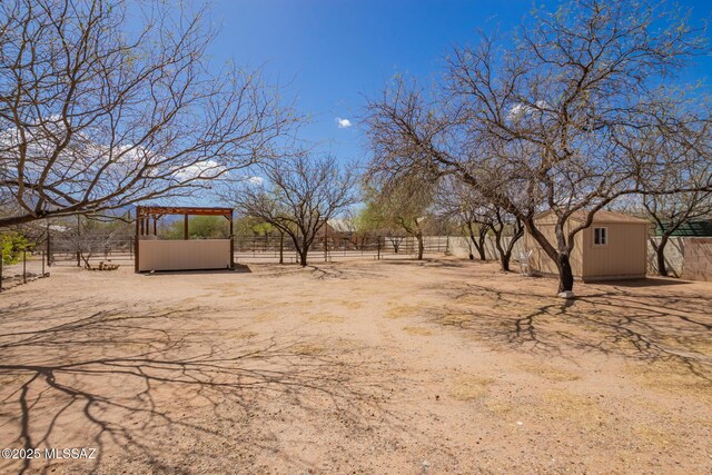 4720 E Wagon Train Rd, Tucson, AZ 85739 - view of yard featuring fence, a storage unit, and an outdoor structure
