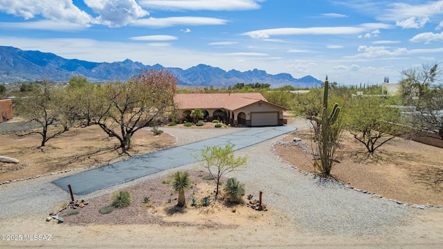 4720 E Wagon Train Rd, Tucson, AZ 85739 - view of front of home with curved driveway, a mountain view, and an attached garage