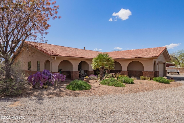 4720 E Wagon Train Rd, Tucson, AZ 85739 - mediterranean / spanish-style home featuring a tiled roof, driveway, stucco siding, and an attached garage
