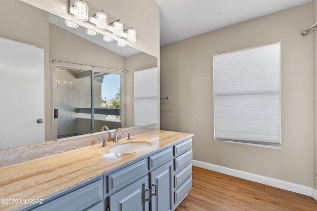 full bathroom with a shower stall, wood finished floors, vanity, and baseboards
