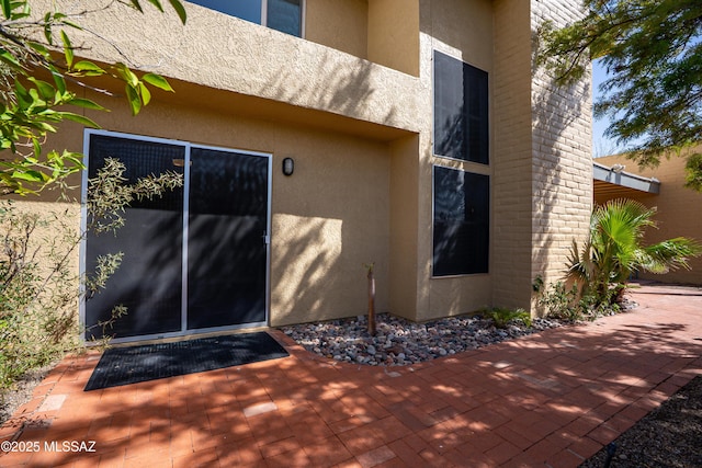 doorway to property with a patio and stucco siding