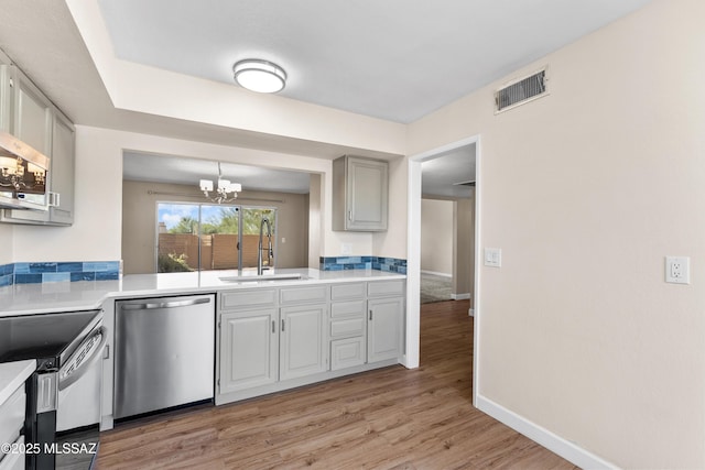 kitchen with visible vents, a notable chandelier, a sink, light countertops, and stainless steel appliances