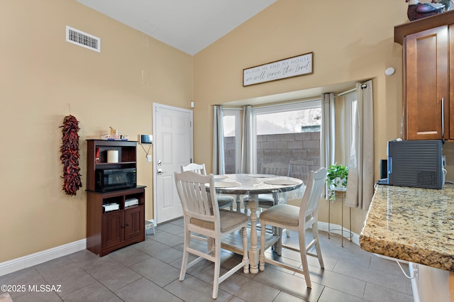9704 E Paseo, San Rosendo, Tucson, AZ 85747 - dining space featuring visible vents, baseboards, vaulted ceiling, and light tile patterned floors