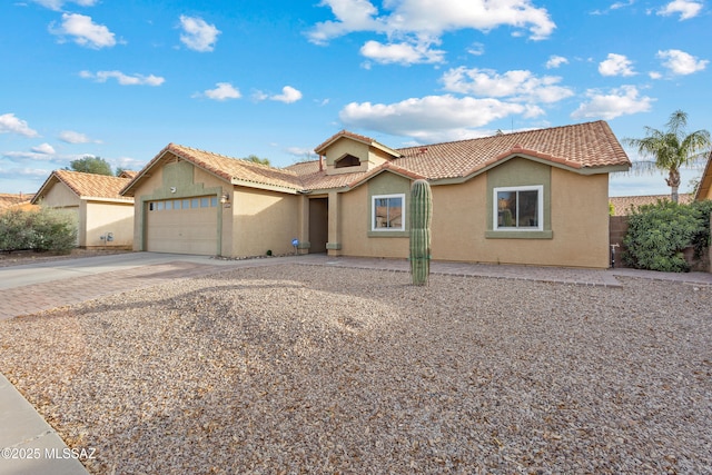 9704 E Paseo, San Rosendo, Tucson, AZ 85747 - view of front of property featuring a tiled roof, a garage, stucco siding, and driveway