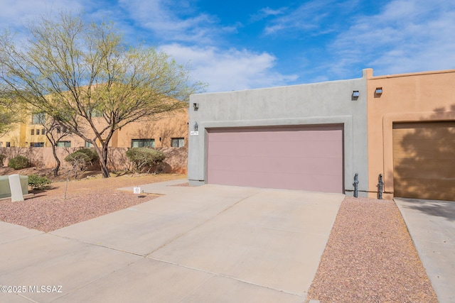 4173 N Fortune Loop, Tucson, AZ 85719 - pueblo-style house featuring stucco siding, concrete driveway, and a garage