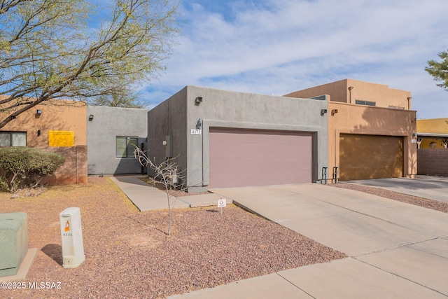 4173 N Fortune Loop, Tucson, AZ 85719 - pueblo-style house with an attached garage, driveway, and stucco siding