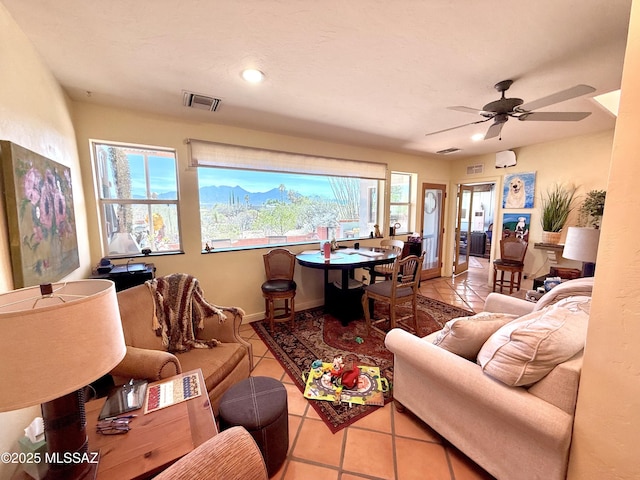 tiled living area with visible vents, baseboards, and ceiling fan