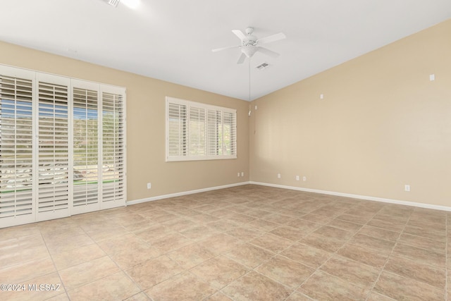 empty room with light tile patterned flooring, baseboards, visible vents, and ceiling fan