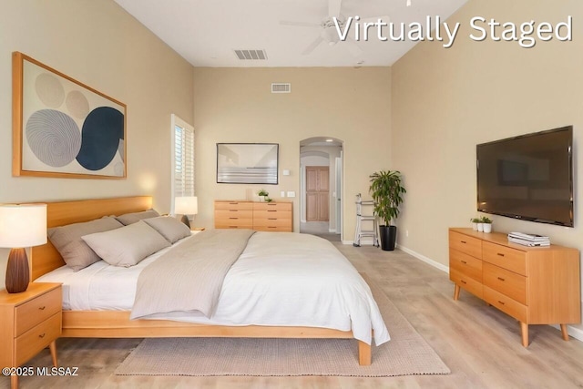 bedroom featuring baseboards, visible vents, and arched walkways