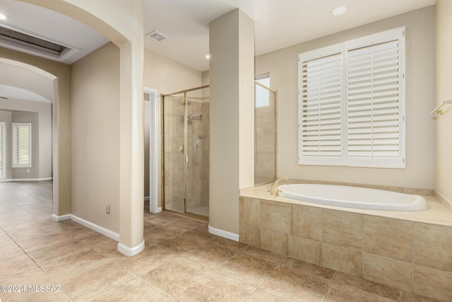 bathroom featuring a stall shower, tile patterned floors, a garden tub, baseboards, and visible vents