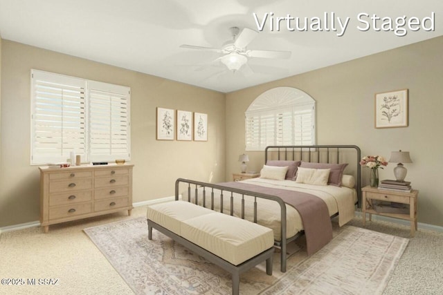 bedroom featuring light carpet, baseboards, and ceiling fan
