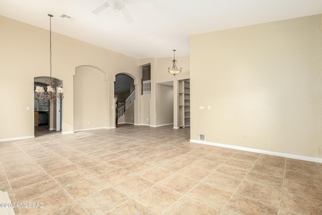 interior space with visible vents, baseboards, stairs, ceiling fan, and arched walkways