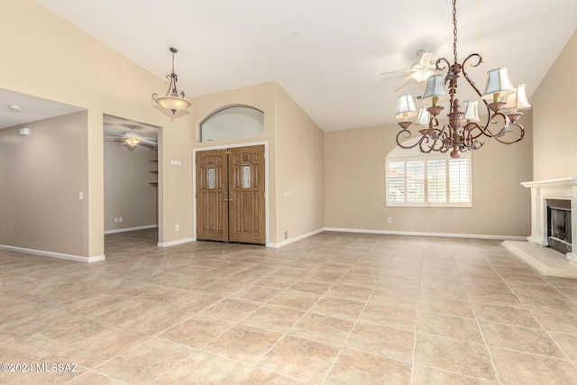foyer entrance with a fireplace with raised hearth, lofted ceiling, baseboards, light tile patterned floors, and ceiling fan with notable chandelier