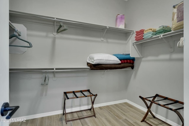 walk in closet with wood finished floors