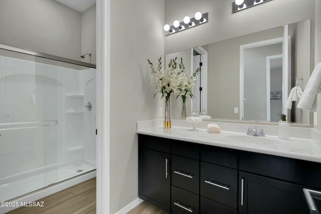 bathroom featuring vanity, a stall shower, and wood finished floors