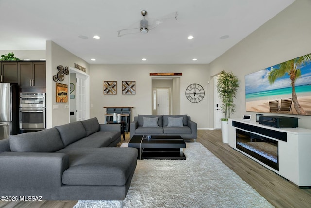 living room with recessed lighting, baseboards, and wood finished floors