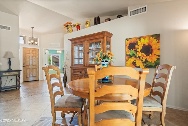 dining room featuring a chandelier, lofted ceiling, and visible vents