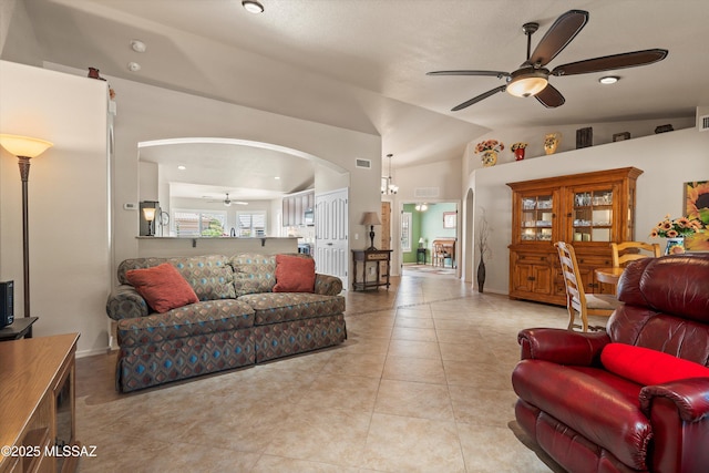 living room featuring visible vents, light tile patterned floors, arched walkways, ceiling fan, and vaulted ceiling