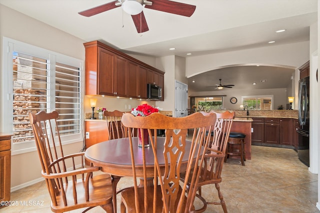 dining area with arched walkways, ceiling fan, and recessed lighting