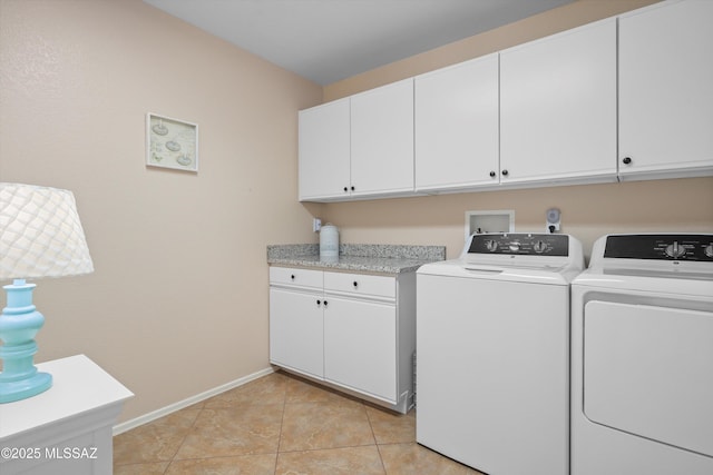 laundry area with washer and dryer, light tile patterned floors, baseboards, and cabinet space