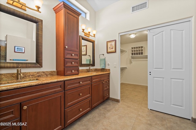 full bathroom with tile patterned floors, double vanity, a sink, and visible vents